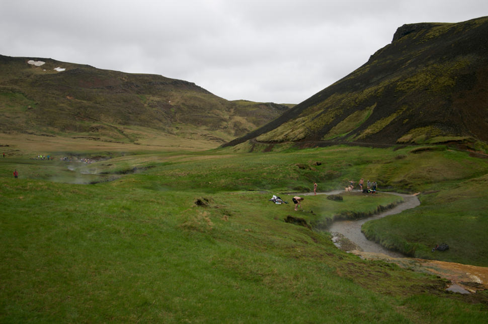 Warm river winding through the Reykjadalur Valley with people on the banks