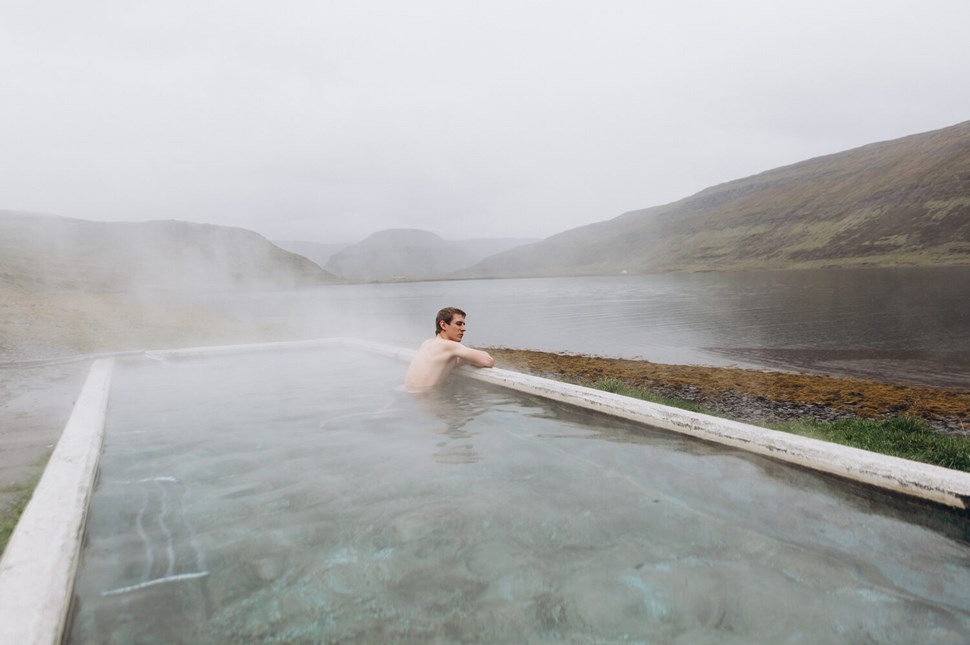 Man relaxing in the natural hot spring pool in Iceland