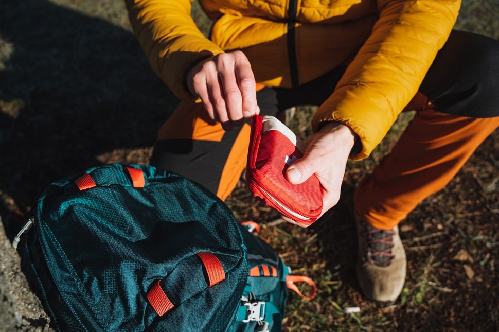 Open a first aid kit with medicines, a hiker on a hike uses a first aid kit, tourist equipment, survival in the forest