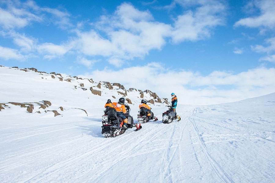 Group of people snowmobiles on glacier
