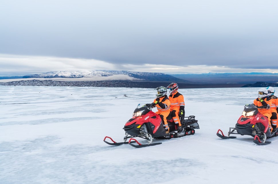 Two couples snowmobiling on glacier