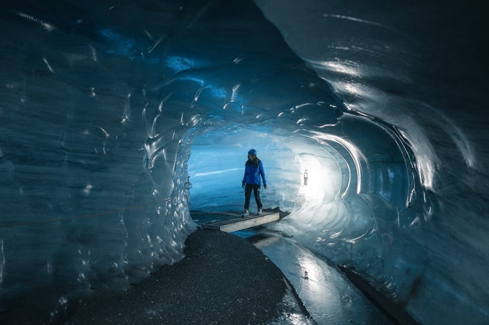 Woman crossing bridge in ice cave