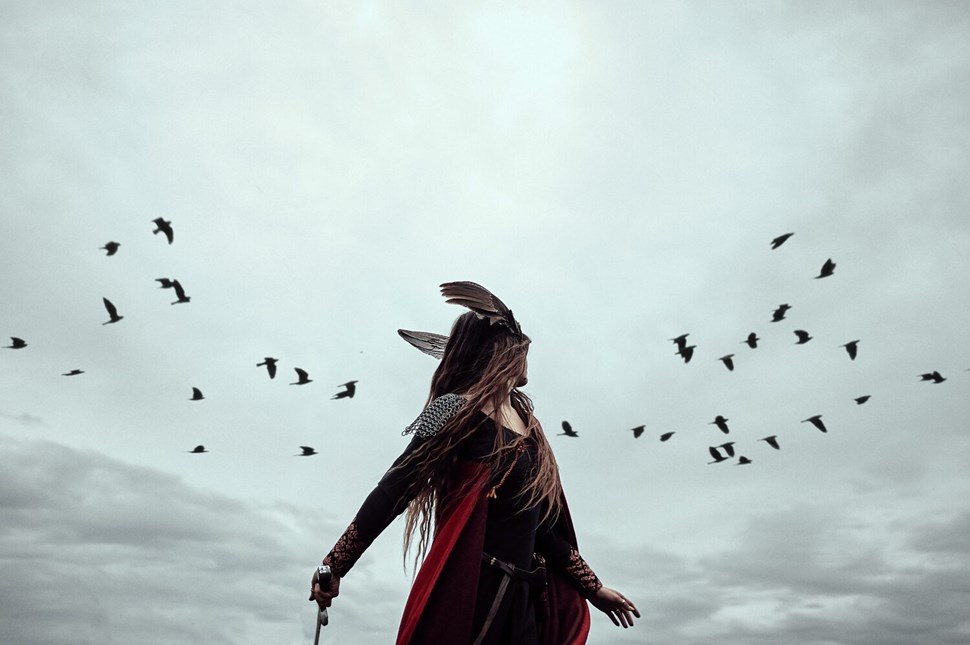 Woman with costume and ravens in sky