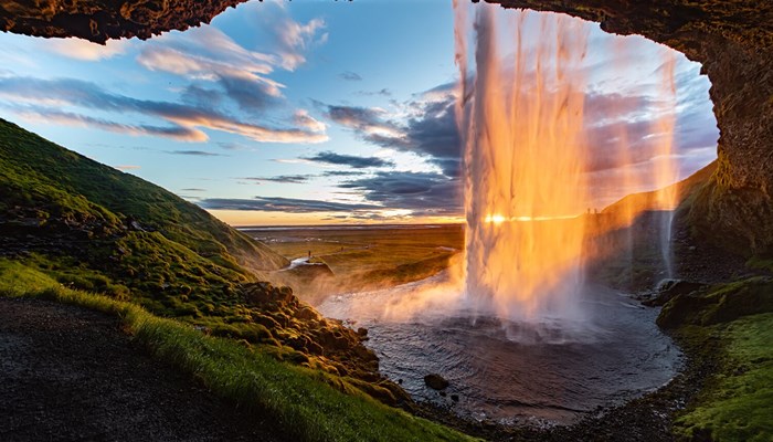 View from inside of waterfall at unset in Icelan