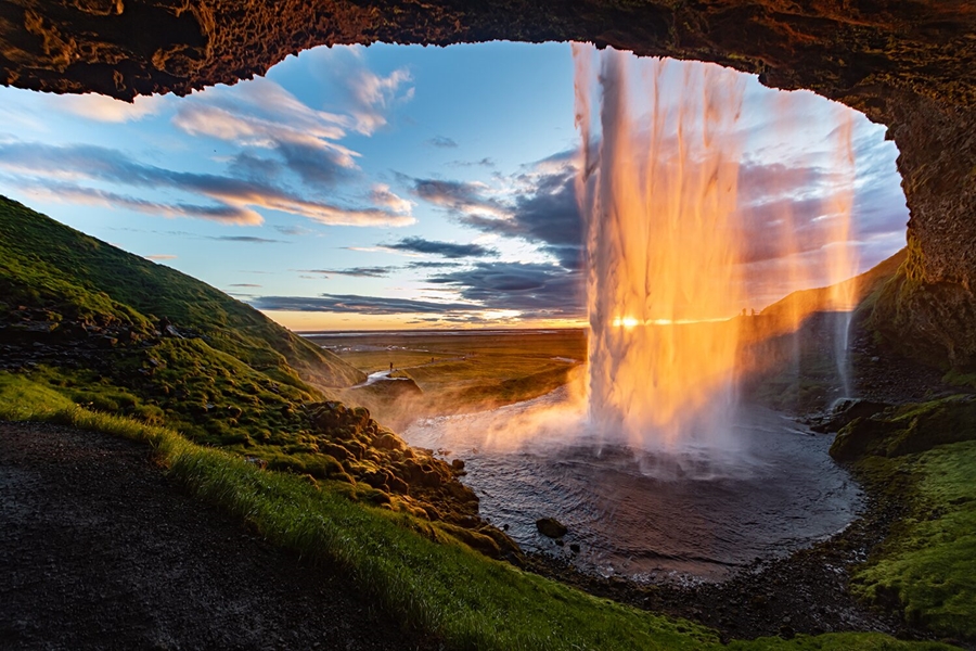 View from inside of waterfall at unset in Icelan