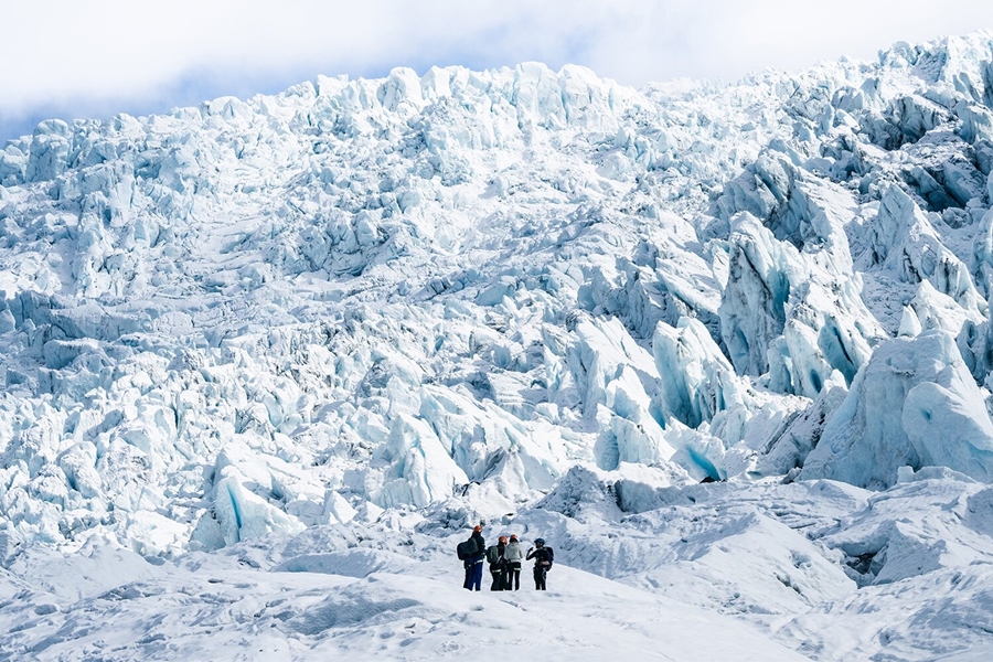 Few people standing by majestic glacier crevasses