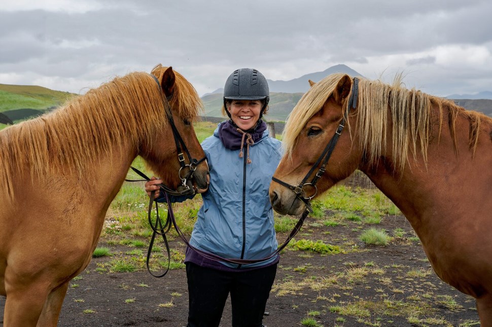 Lady smiling between two horses