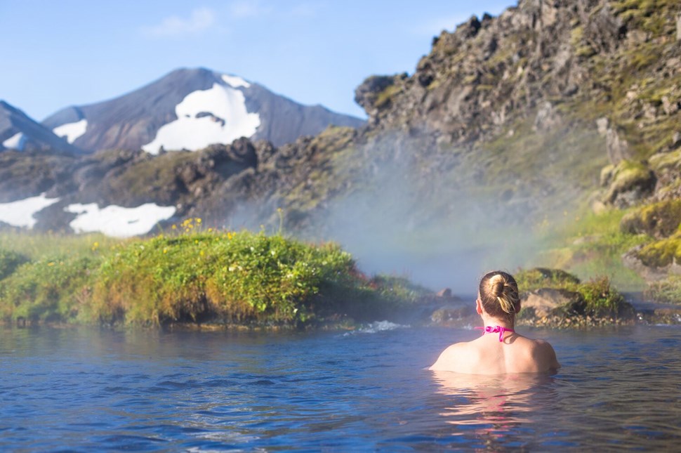 Woman soaking in steaming hot spring 