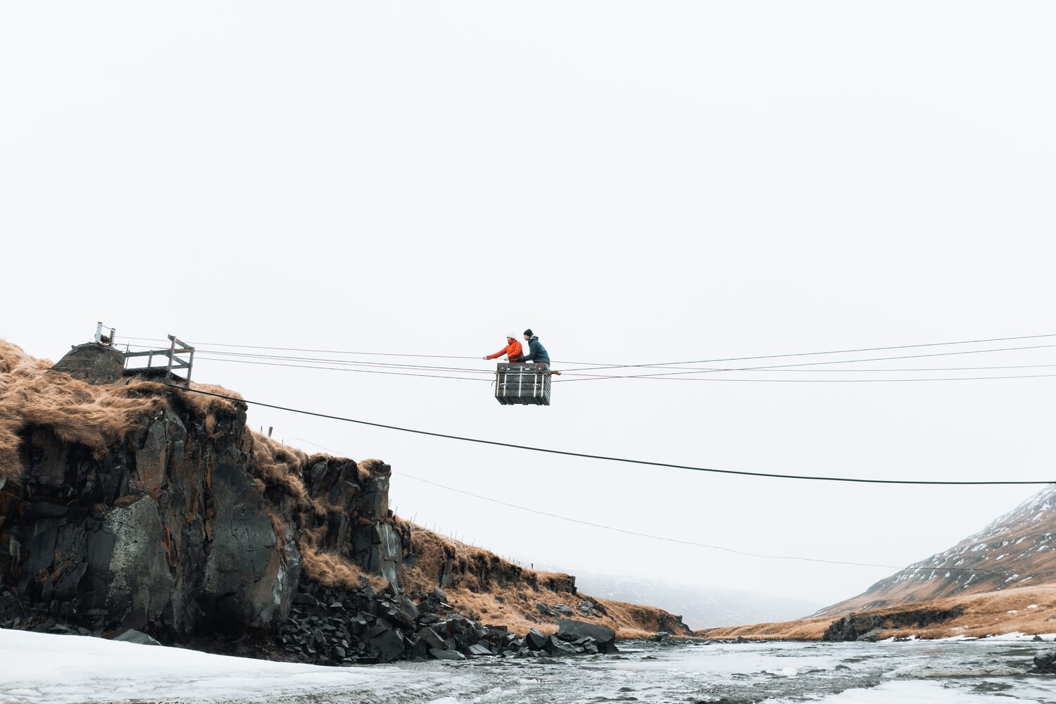 People crossing river by cable bridge