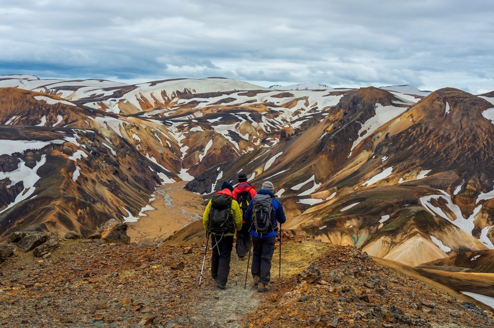 Two hikers in snow-capped Landmannalaugar view from behind