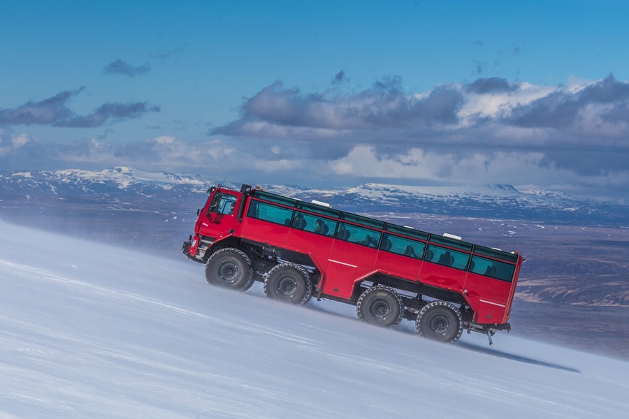 Red giant truck driving on glacier