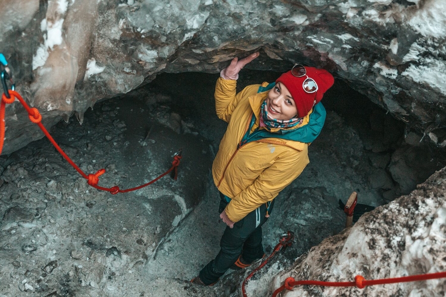 Woman with yellow jacket in ice cave