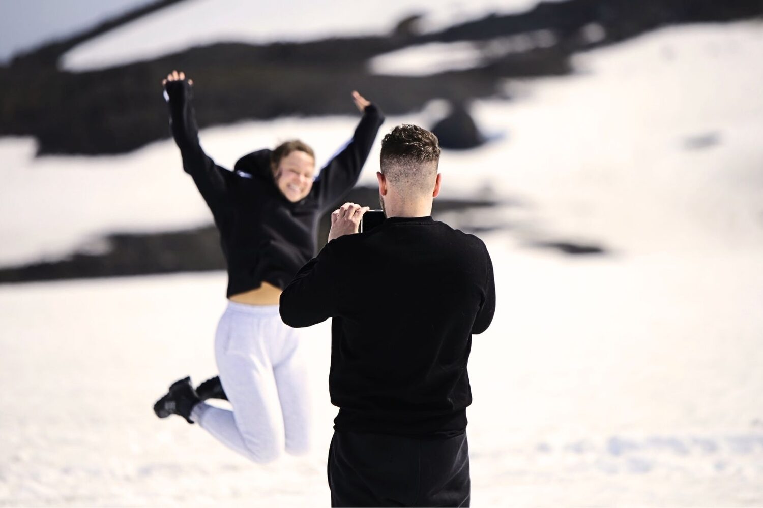 Happy couple taking photos on glacier