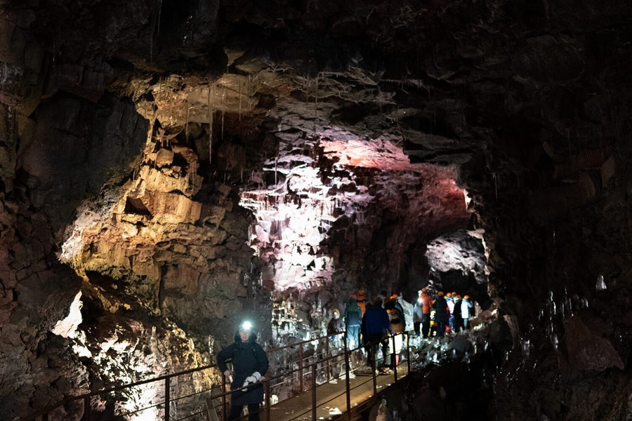 Guided tour in dark lava cave in Iceland