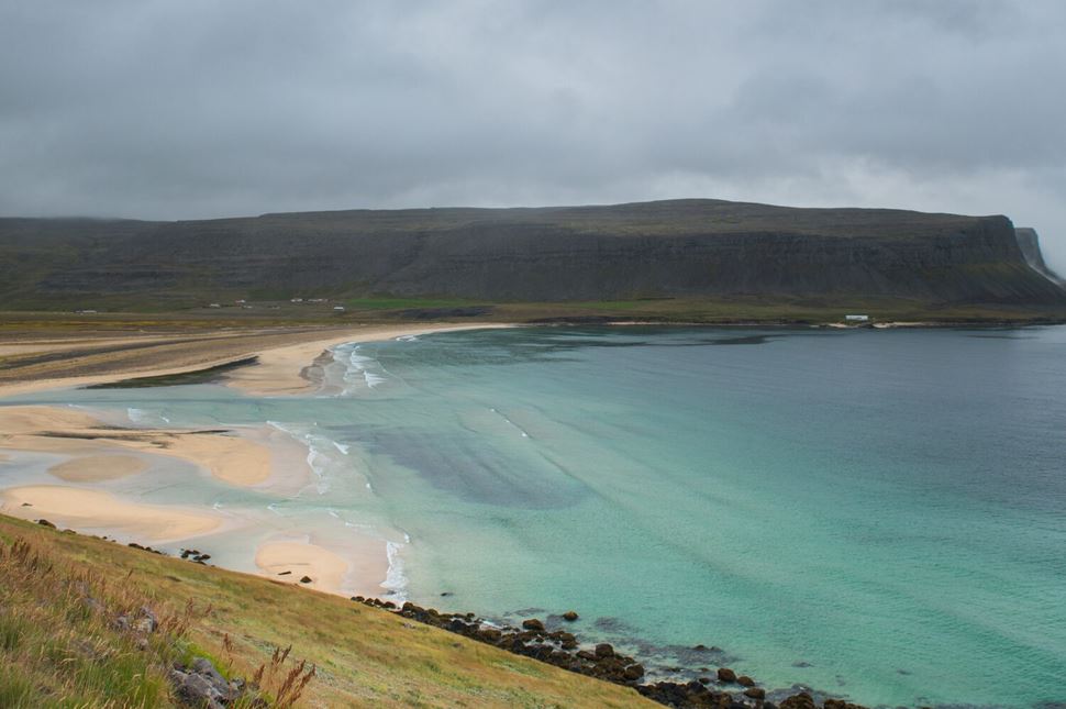 Ariel view of clear seawater and coast at Breidavik in Westfjords.