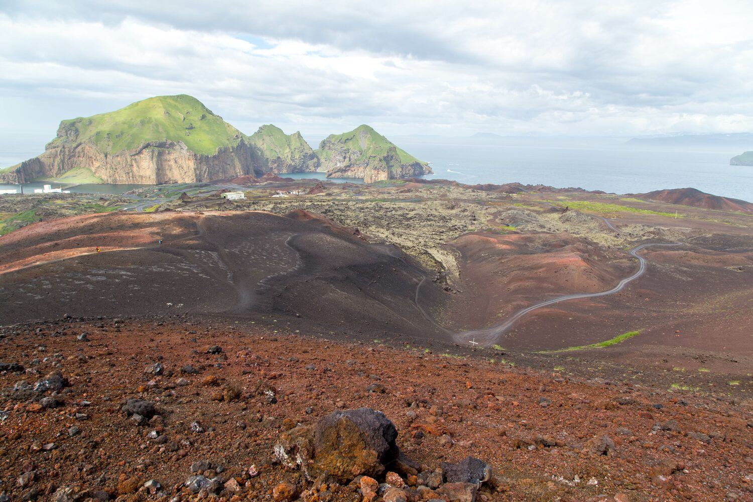 Blick vom Vulkan Eldfell volanic rocks and ash landscape with islands in sea background.