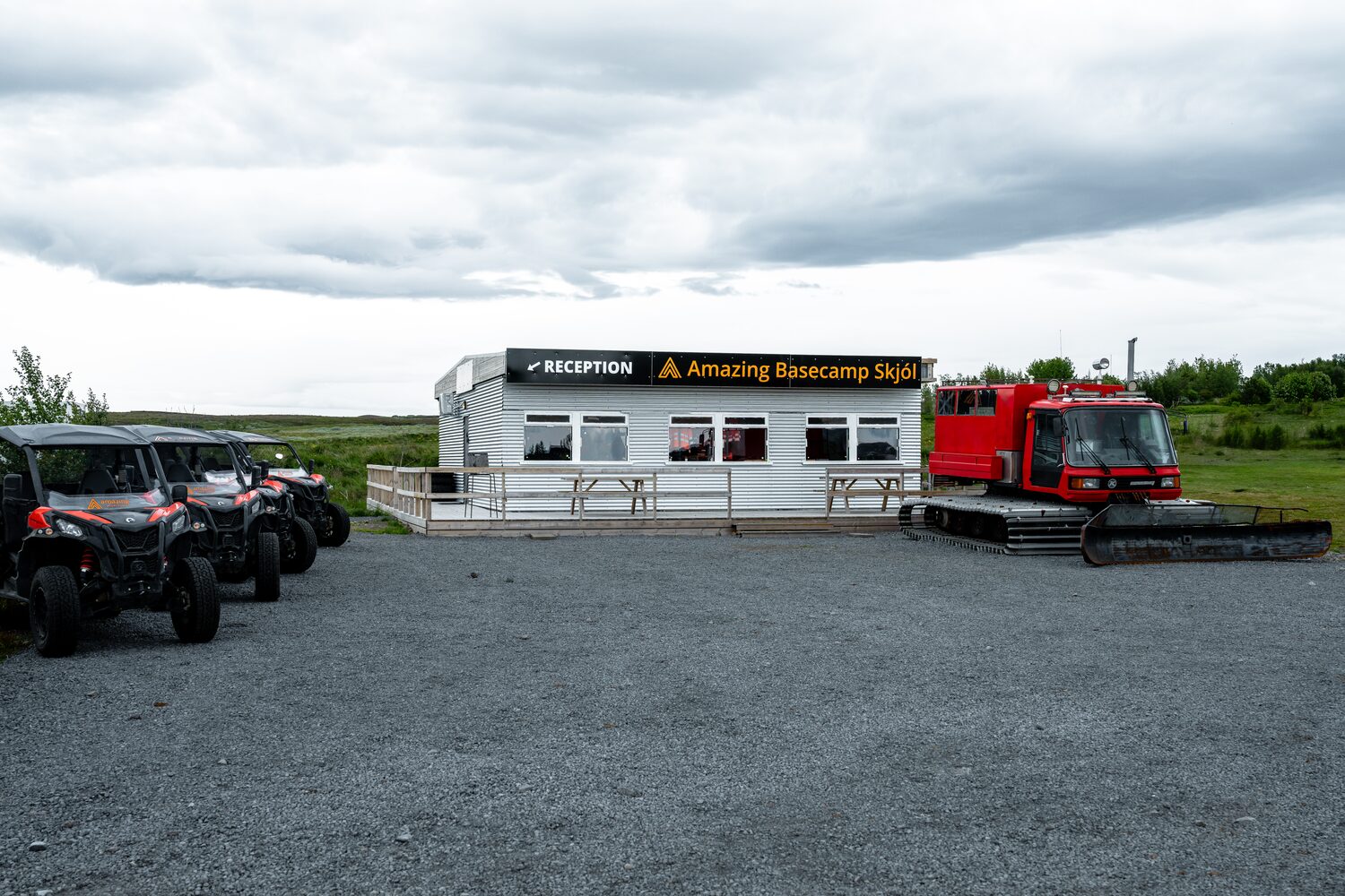 Arctic Adventures Skjol Basecamp Reception hut with parked black buggy vehicles outside in parking lot 
