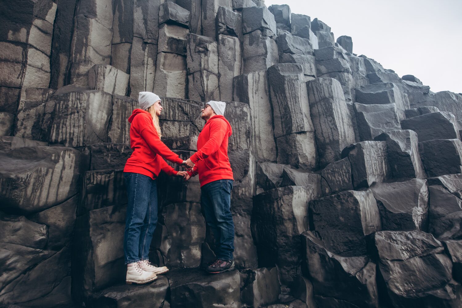Couple with red jumpers on basalt columns
