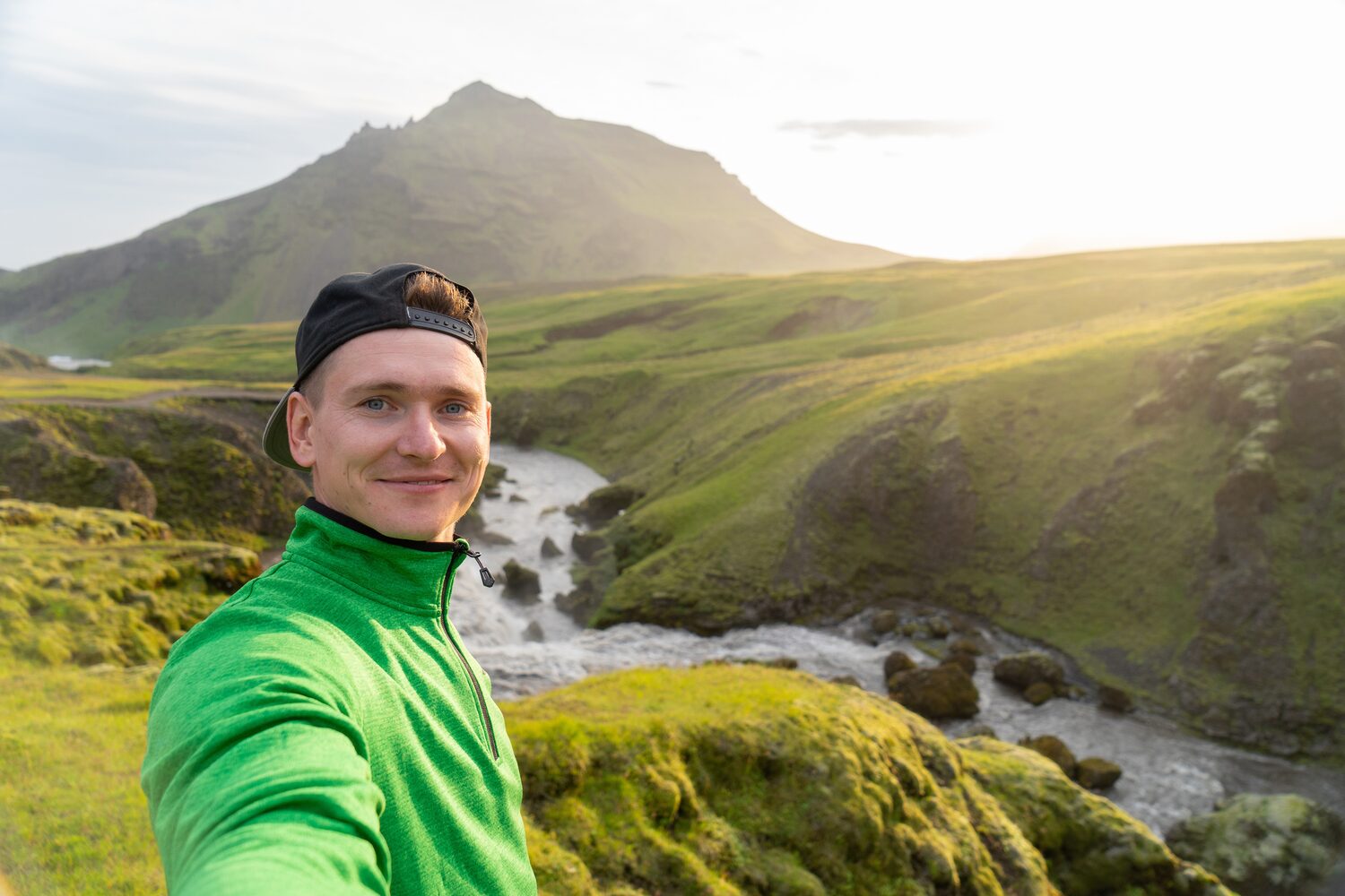 Man with green jumper taking selfie with Icelandic view