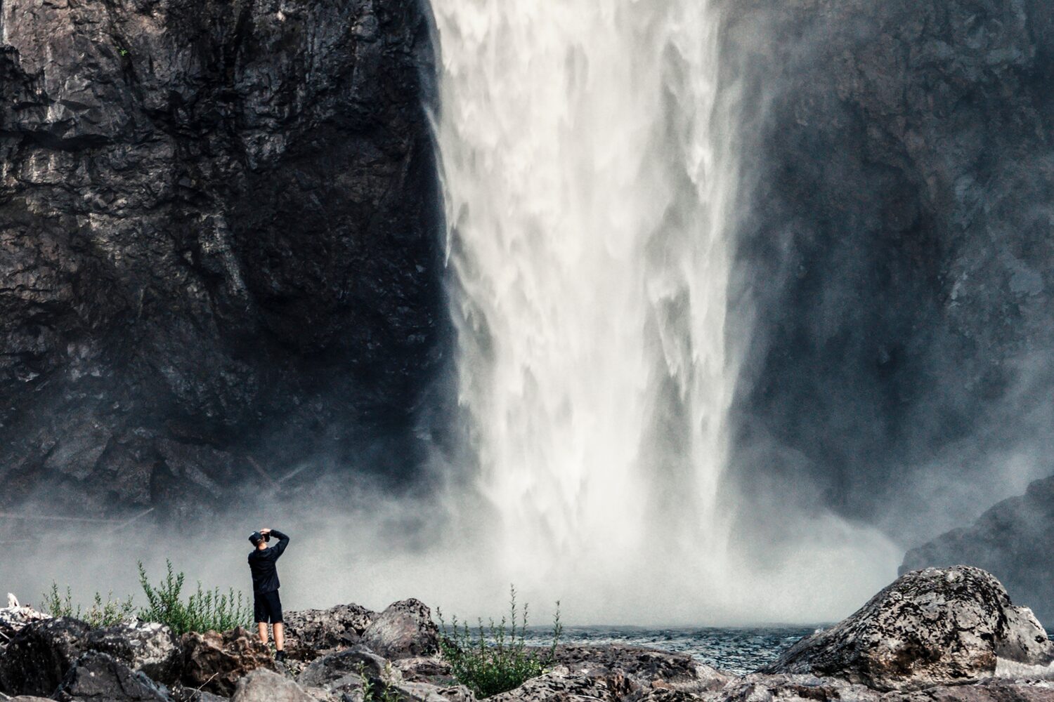 Man taking photos of huge waterfall
