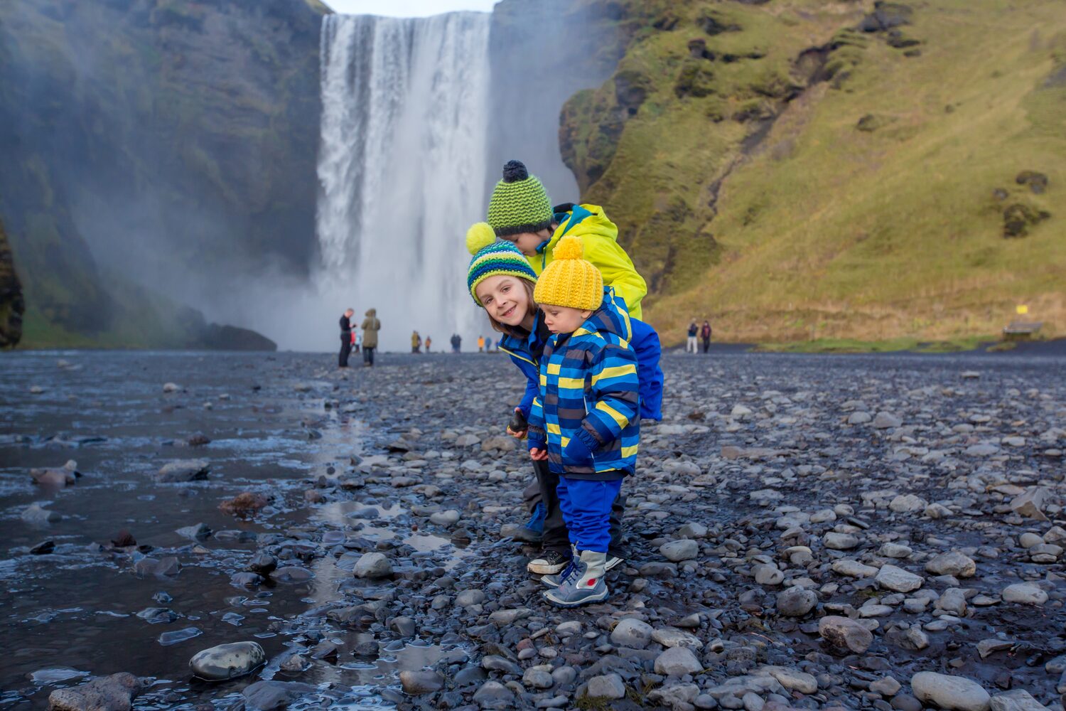 Children by Skogafoss waterfall in Iceland
