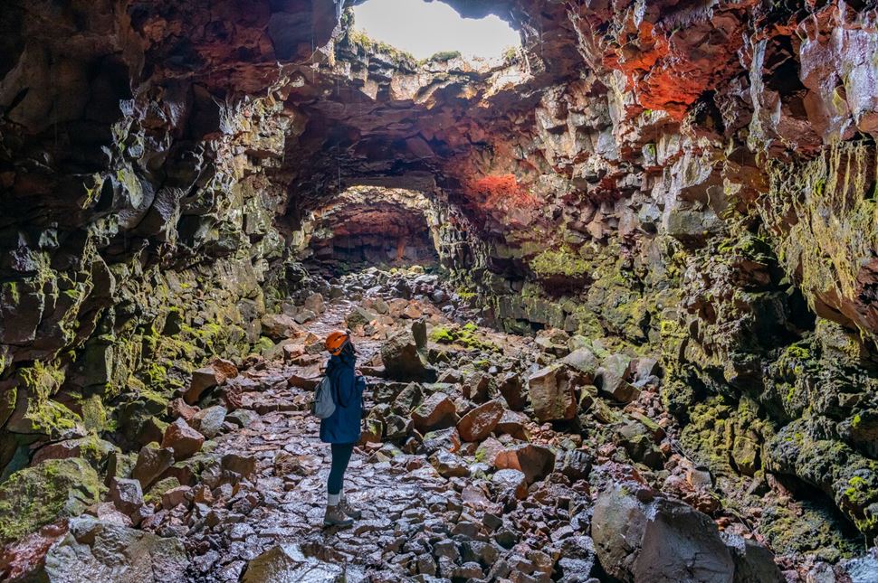 Different Colored Lava Rock Tunnel Lady walking inside lava tunnel with colored lava rock