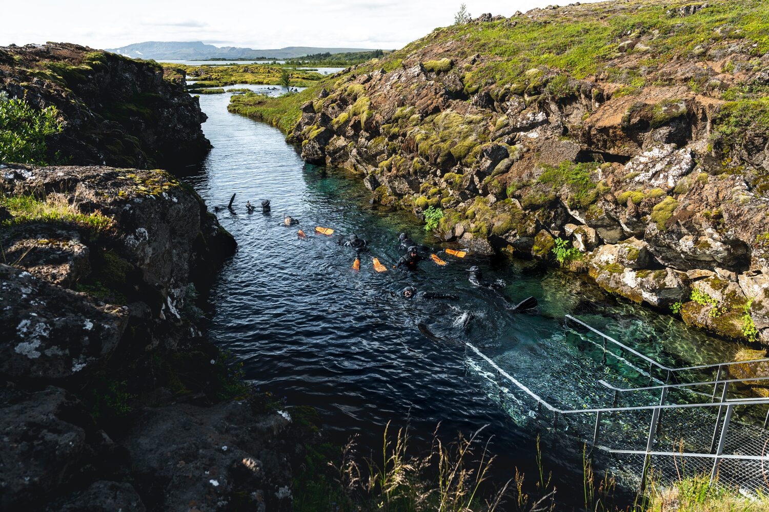 People with dry suits snorkeling in Silfra 