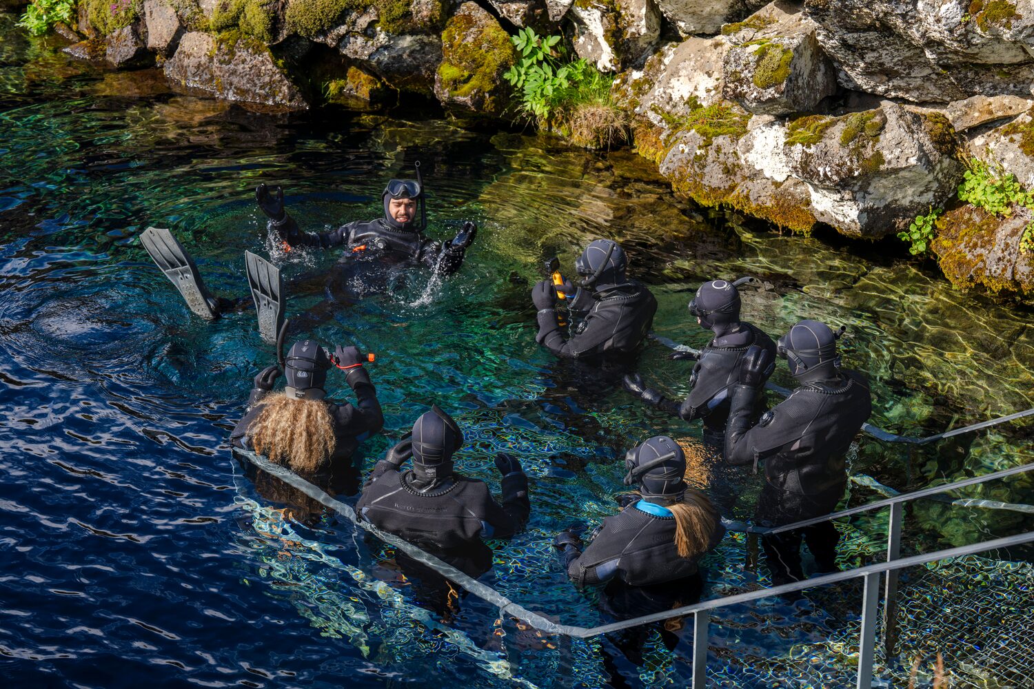 People with snorkeling suits going into Silfra