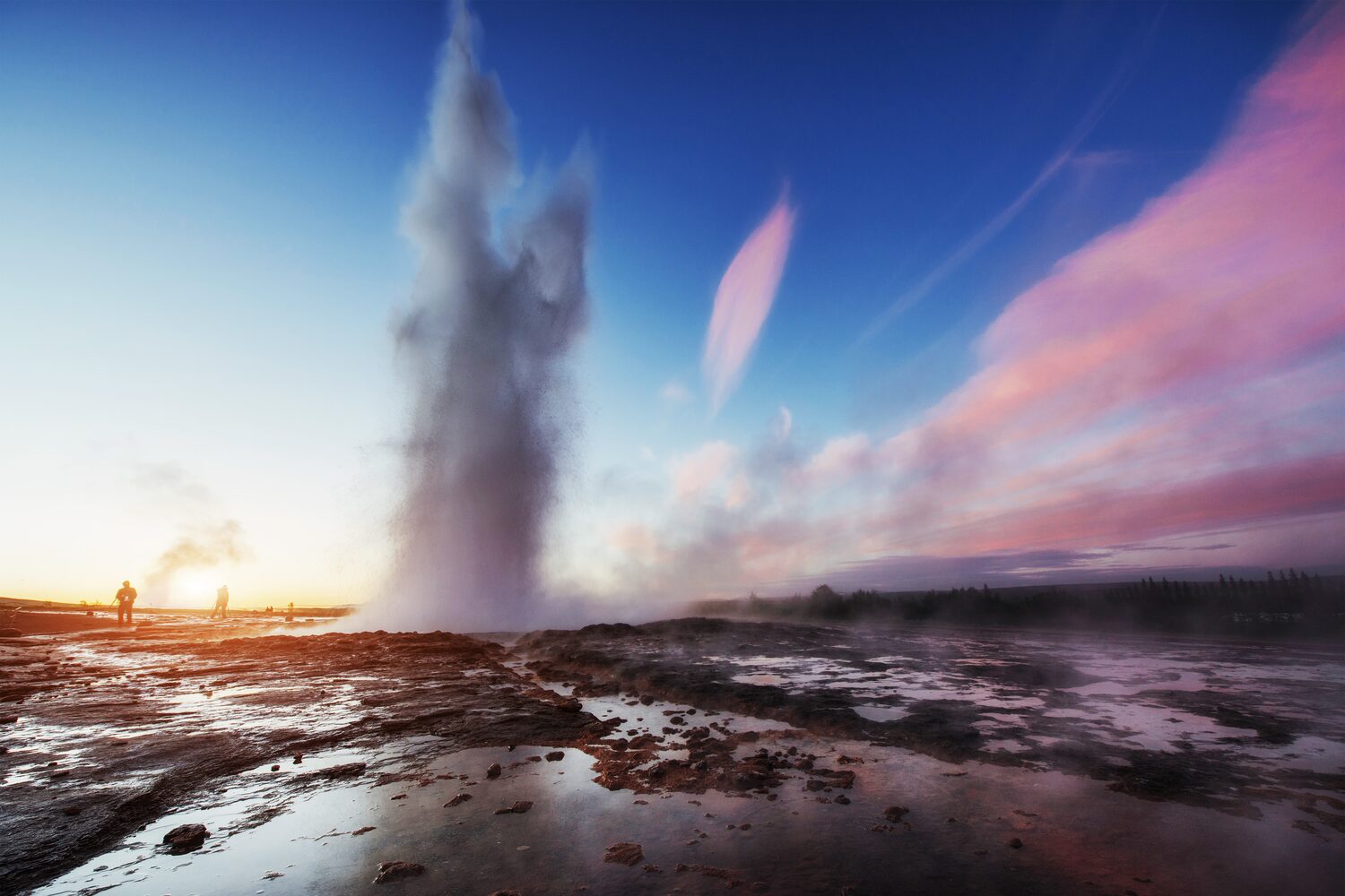 Fantastic sunset Strokkur geyser eruption in Iceland in sunset with pink clouds in the sky 
