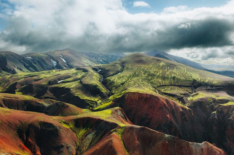 Ariel Shot of Rhyolite mountain  Ariel shot of Rhyolite mountain colors of orange and green landscape with blue cloudy sky