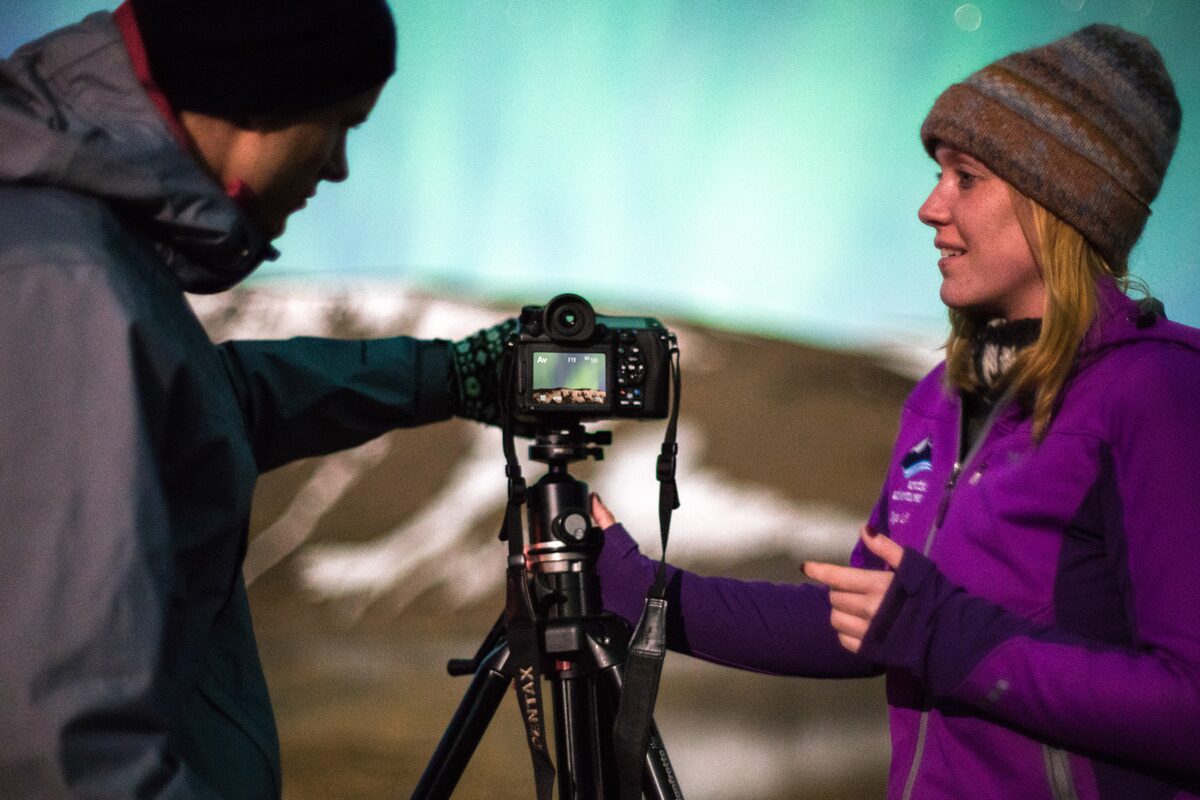 Woman showing for man how to take photos at night