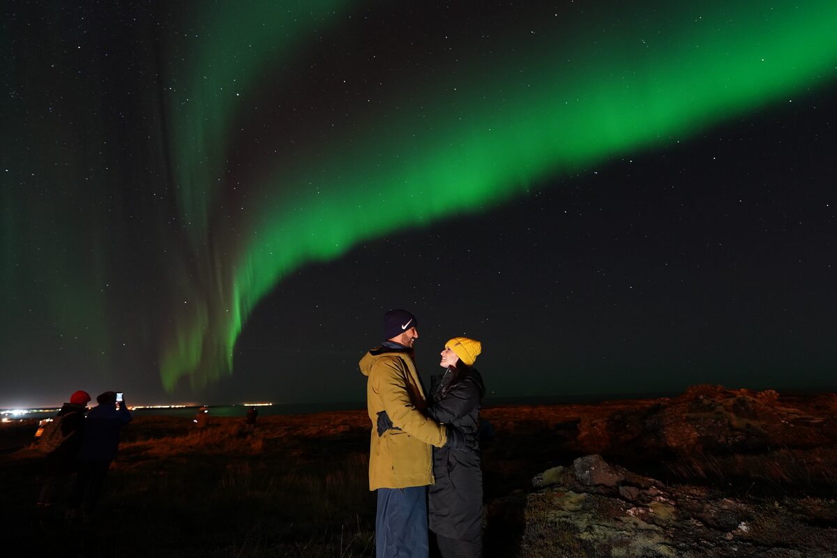 Couple kissing under northern lights