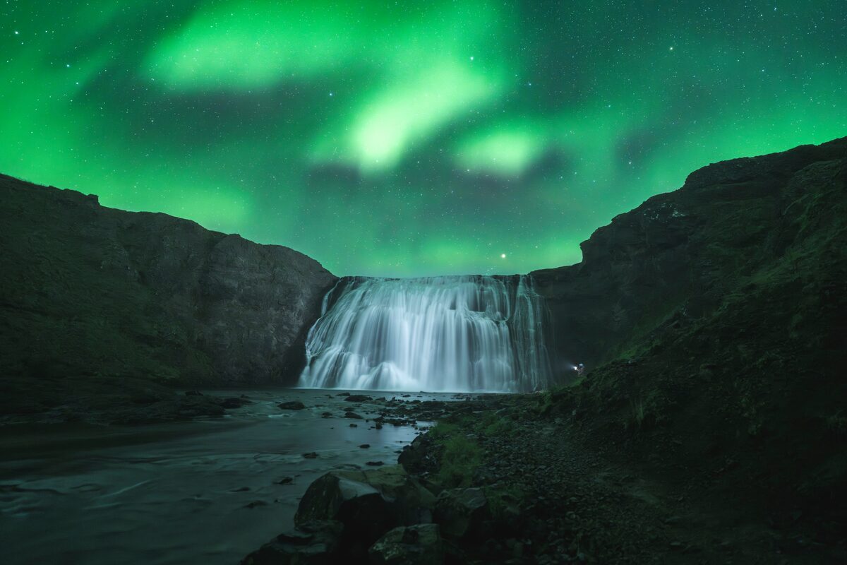 Aurora light above waterfall in Iceland