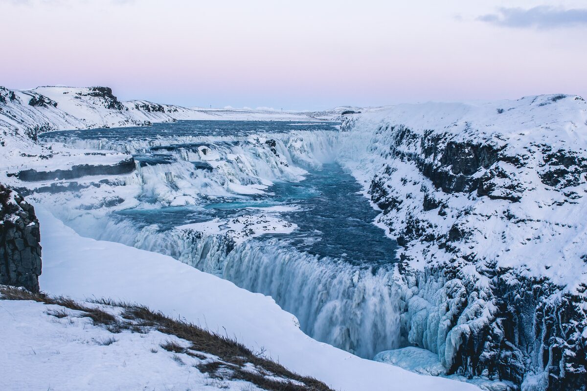 Close up view of gullfoss in winter frozen waterfall with snow covered ground
