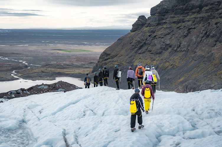 Travelers hiking down glacier in Iceland