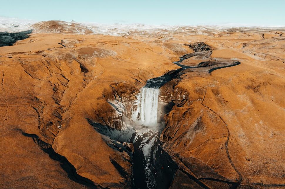 Skogarfoss Ariel Shot Autumn Winter  Far out ariel show of waterfall surrounded by autumn landscape