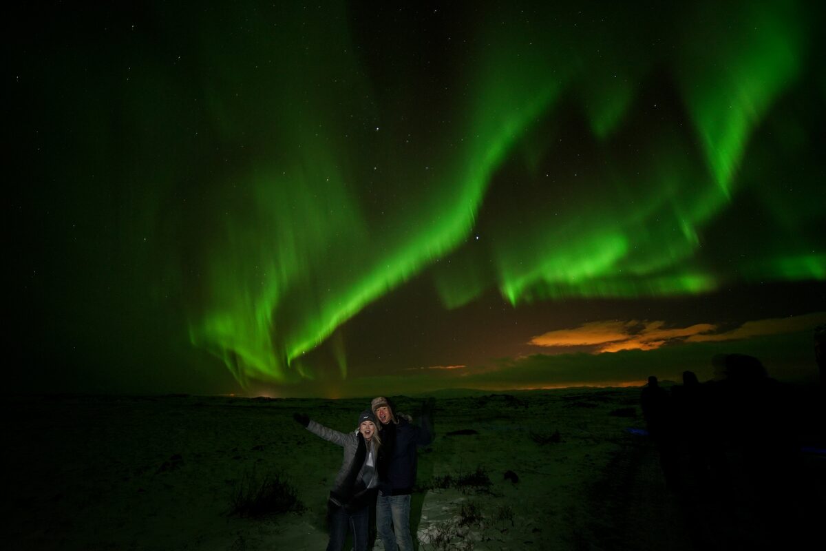 Northern Lights above happy couple