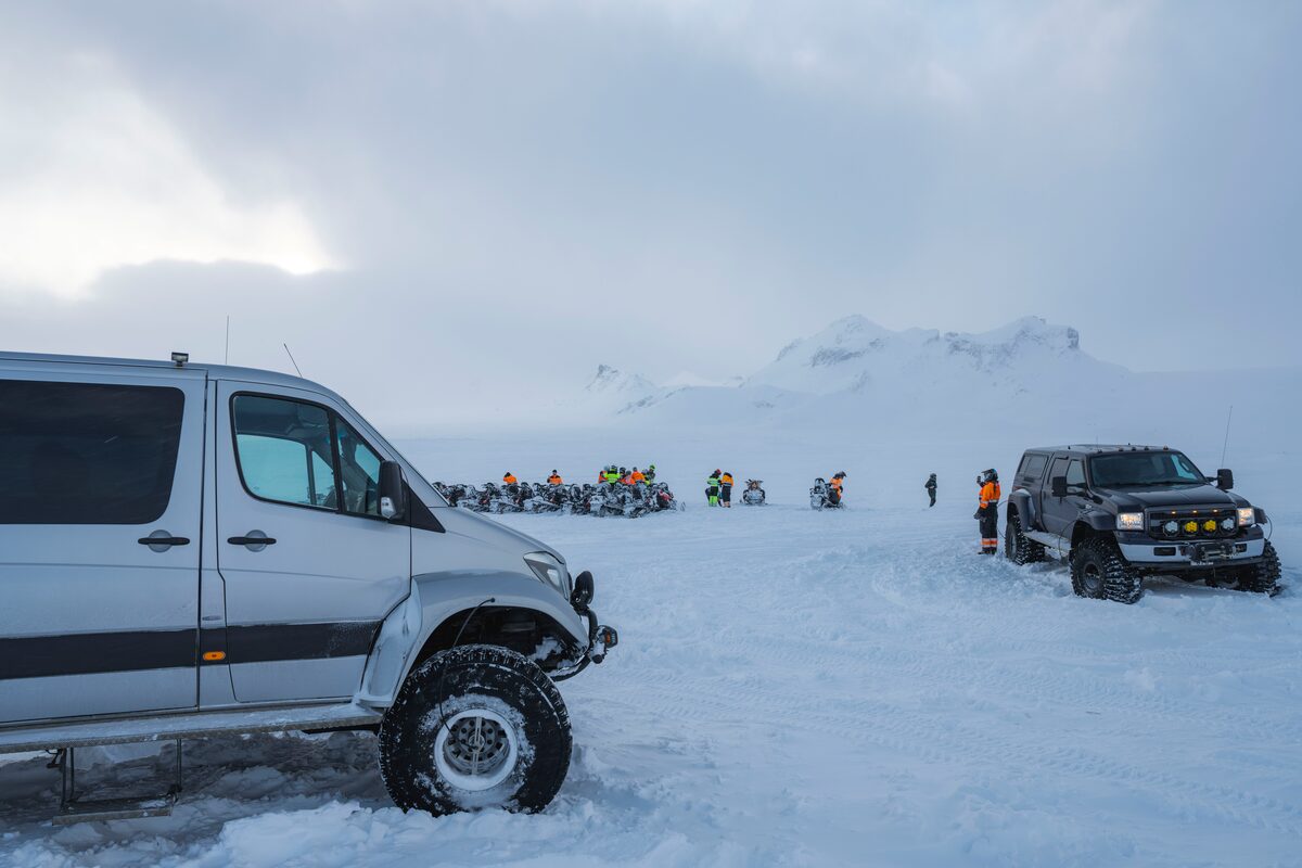 Two super jeeps parked on glacier with snowmobiling group tour 