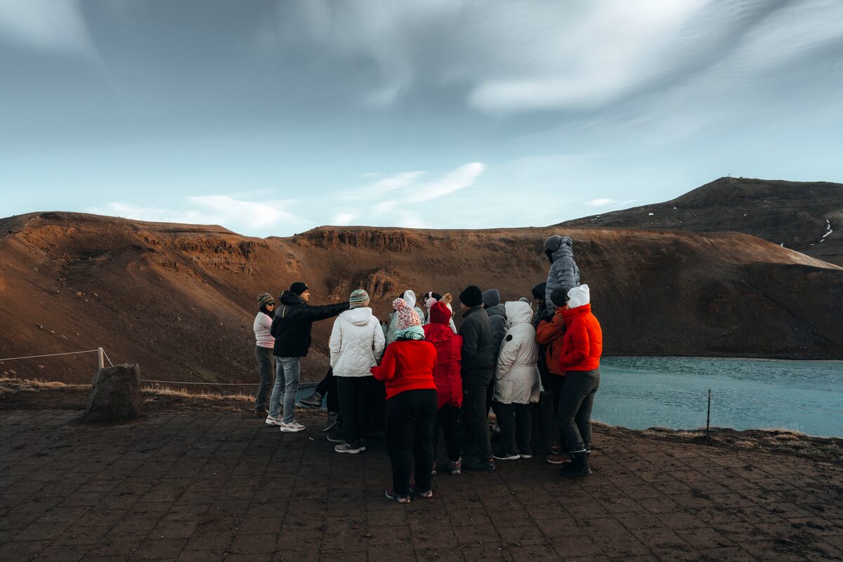 Small tour group standing by enjoying view of Stora-Viti North Iceland 