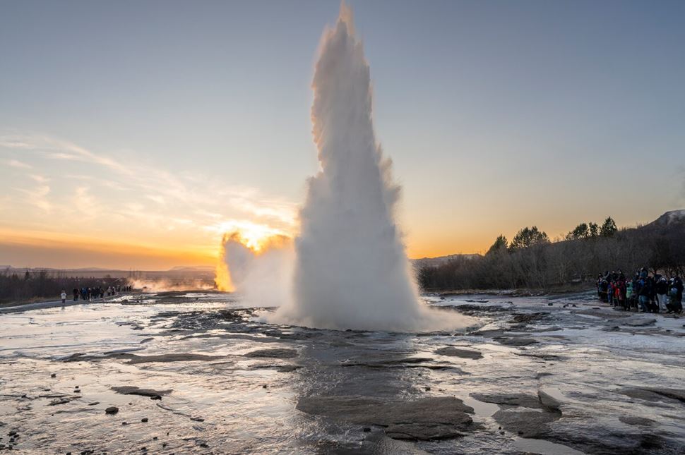 Evening view of geyser eruption when sun goes down