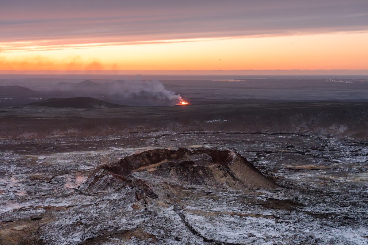 Ariel view of Nordurflug active eruption ash covered ground during sunset