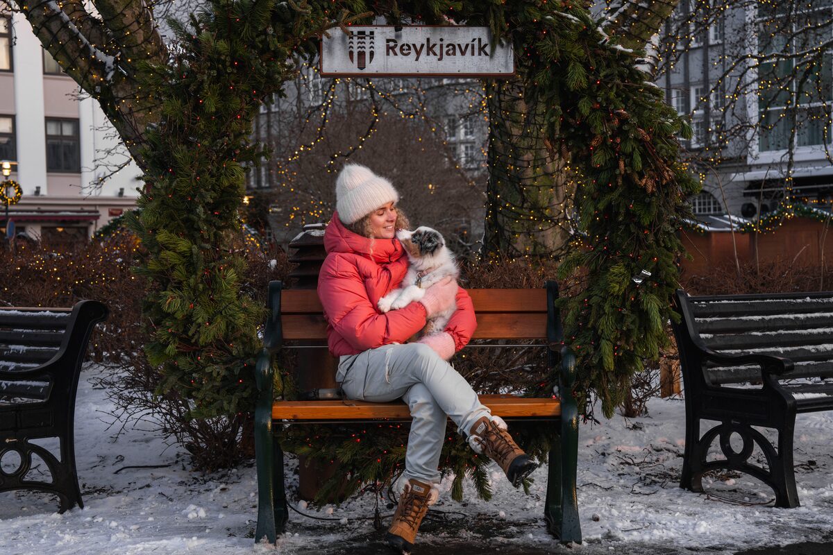 Woman posing for photo by big wreath with dog