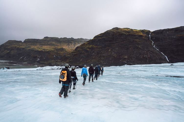 Group walking in a row on glacier