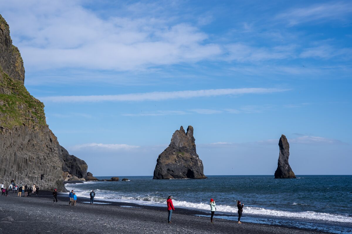 People in black sand beach of Iceland's South Coast