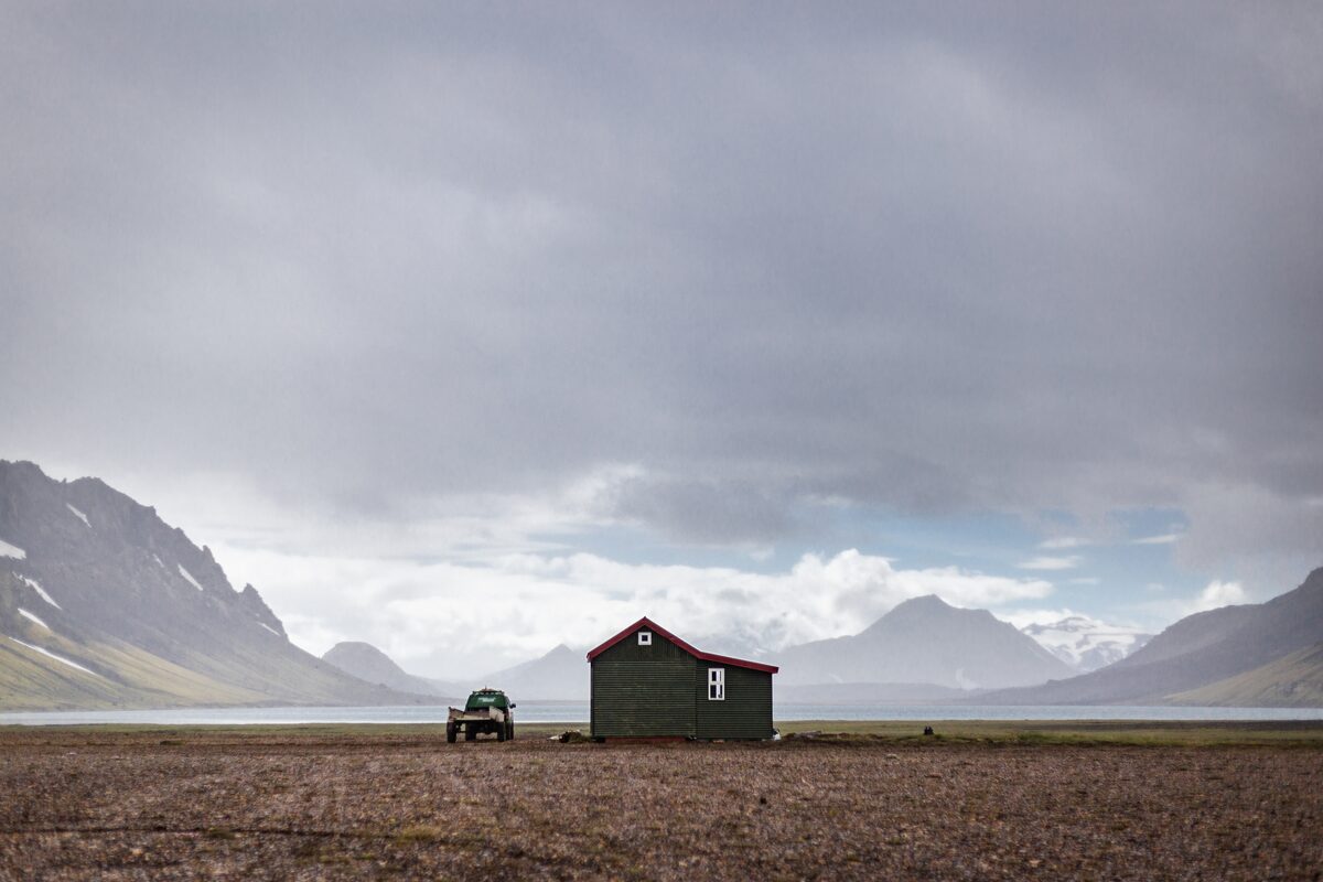 Hut in fields surrounded by mountains
