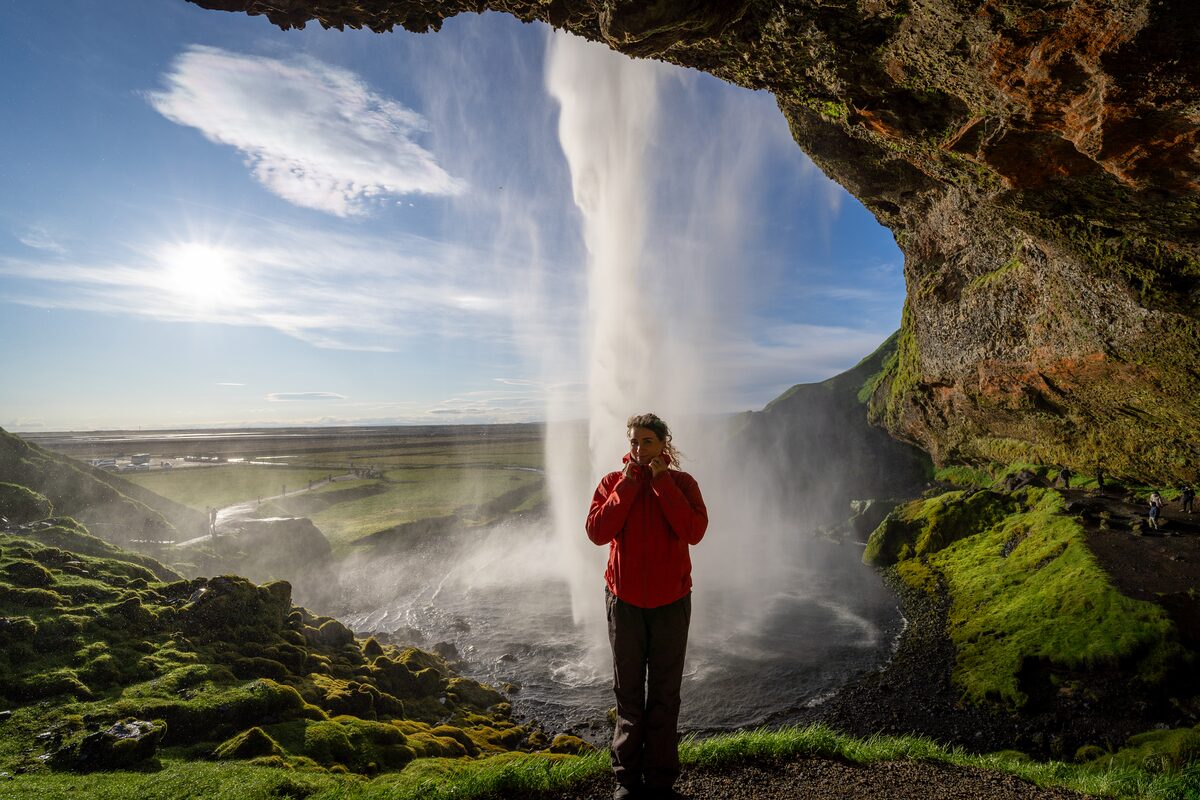 Woman in cave with waterfall