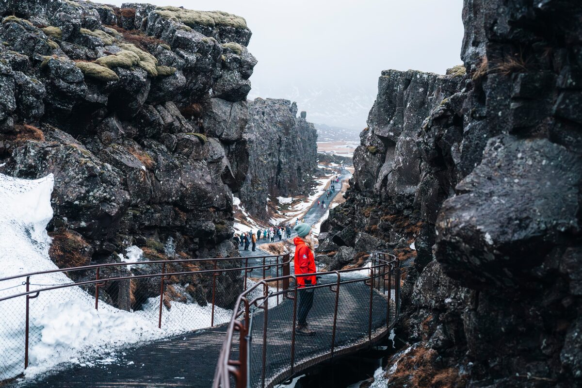 Tourist by walking route through Thingvellir national park in winter