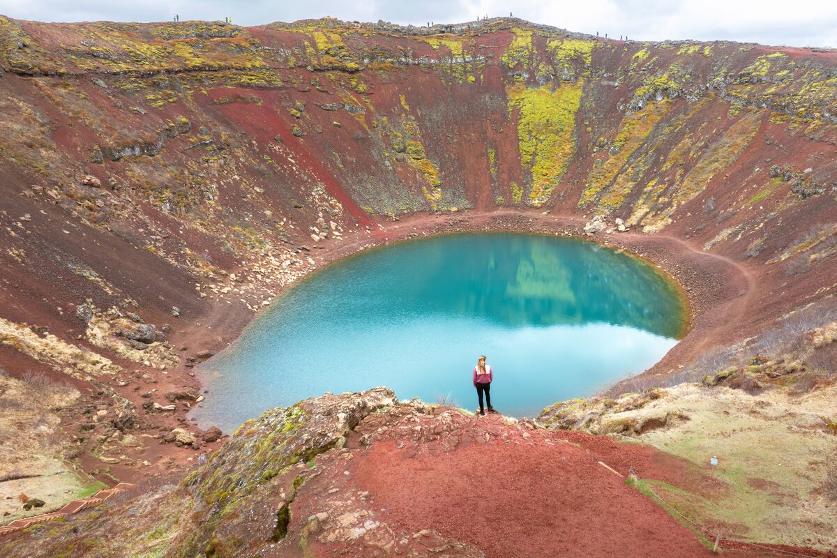 Ariel view of Kerid volcanic crater lake in summer with tourist in distance