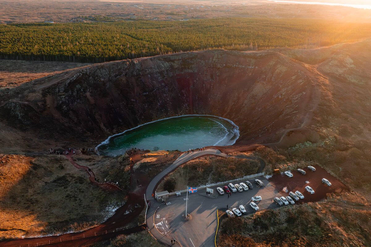 Ariel view of Kerid volcanic crater lake and parking area during sunset