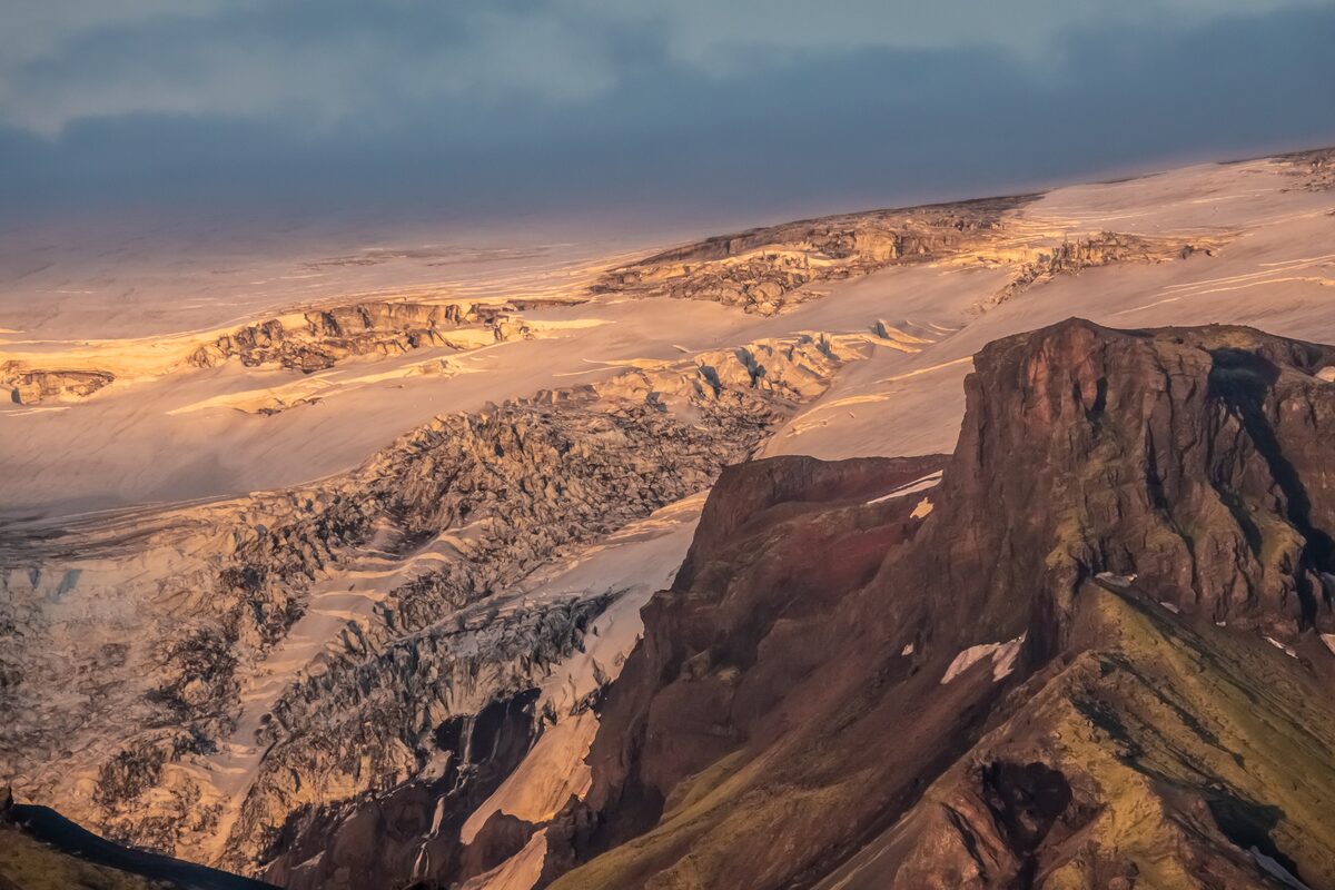 Ariel view of red sunset over glacial mountains covered in snow 